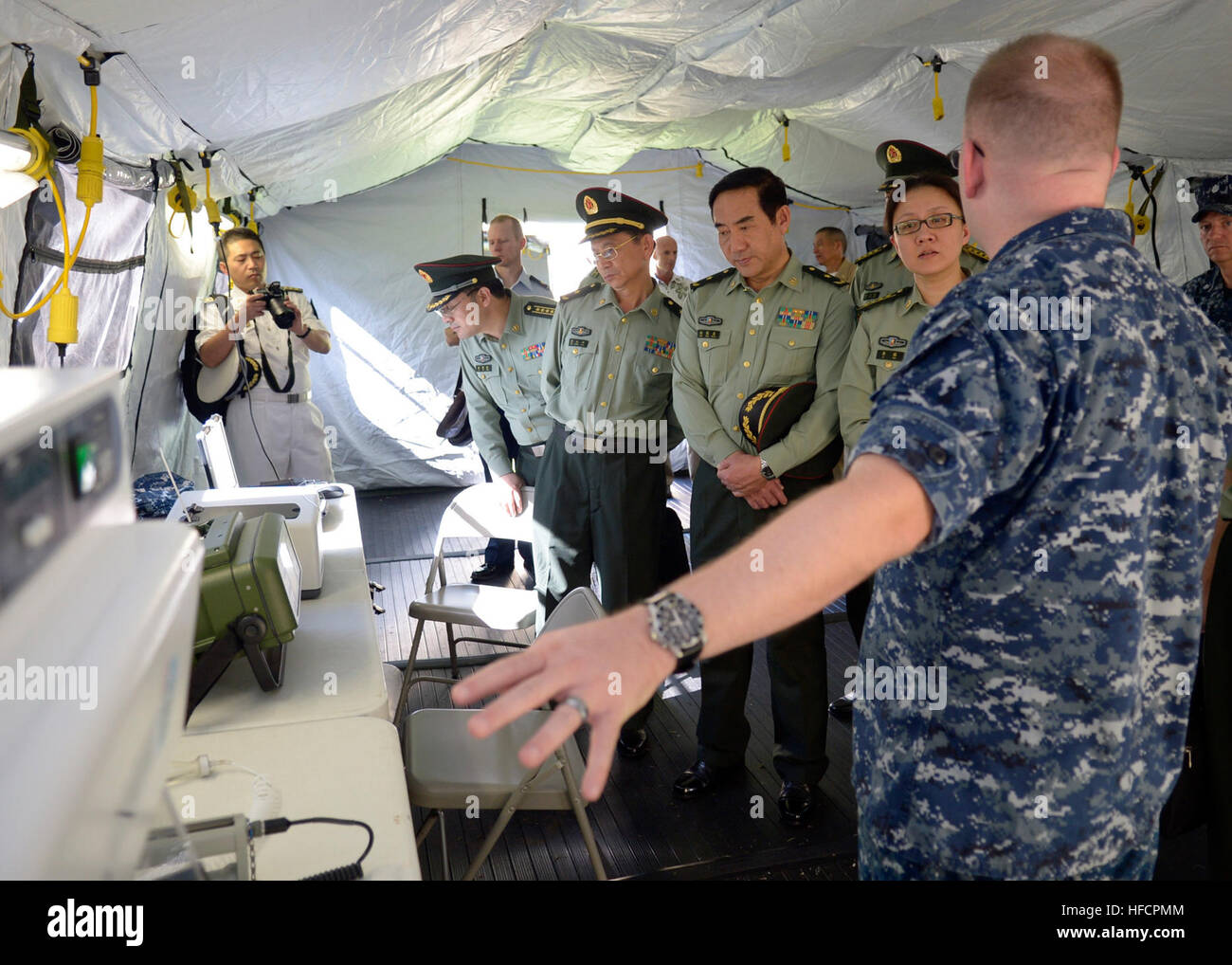 140311-N-DX698-262 JOINT BASE PEARL HARBOR HICKAM (March 11, 2014) Lt. Cmdr. Nicholas Schnauter assigned to Navy Environmental and Preventive Medicine Unit Six (NEPMU-6) explains a microbiology system to a People's Liberation Army (PLA) Senior Medical Delegation Strategic Working Group. The PLA Senior Medical Delegation is visiting PACOM to discuss engagement between the US and PLA Navy hospital ships, medical institutional and educational exchanges and to enhance U.S. and People's Republic of China cooperation within the Asia-Pacific region. (U.S. Navy photo by Mass Communication Specialist 1 Stock Photo