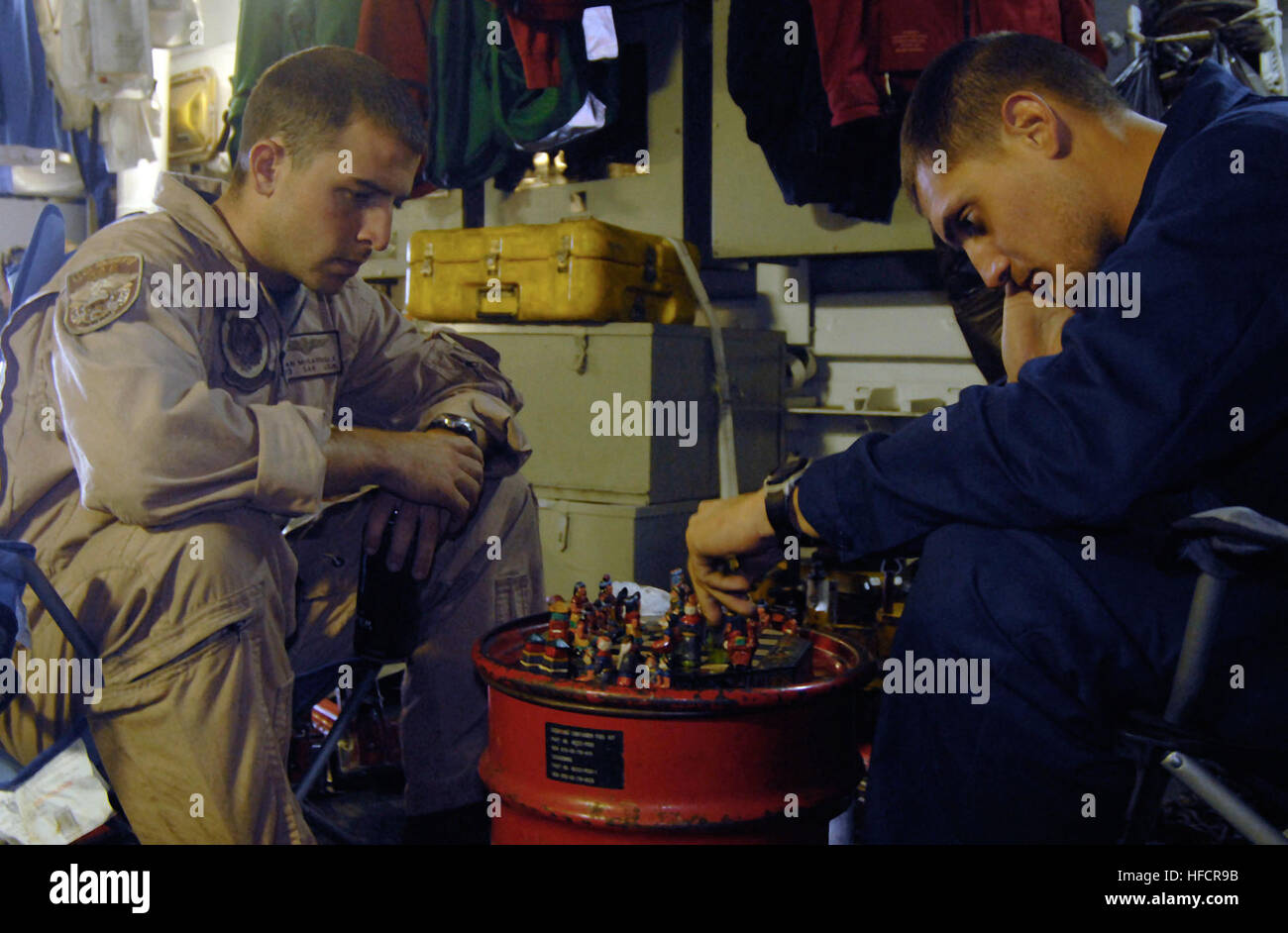 Petty Officer 3rd Class Brian McGarrigle and Petty Officer 3rd Class Jonathan Cronkhite, both assigned to the Battle Cats of Helicopter Anti-Submarine Squadron 43, Detachment 4, based in San Diego, play chess inside the hangar bay of the guided-missile frigate USS Ford. Ford is deployed with Southern Seas 2009, part of the U.S. Southern Command-led Partnership of the Americas mission focusing on strengthening relationship in the Southern Command area of Focus. Playing Chess 182365 Stock Photo
