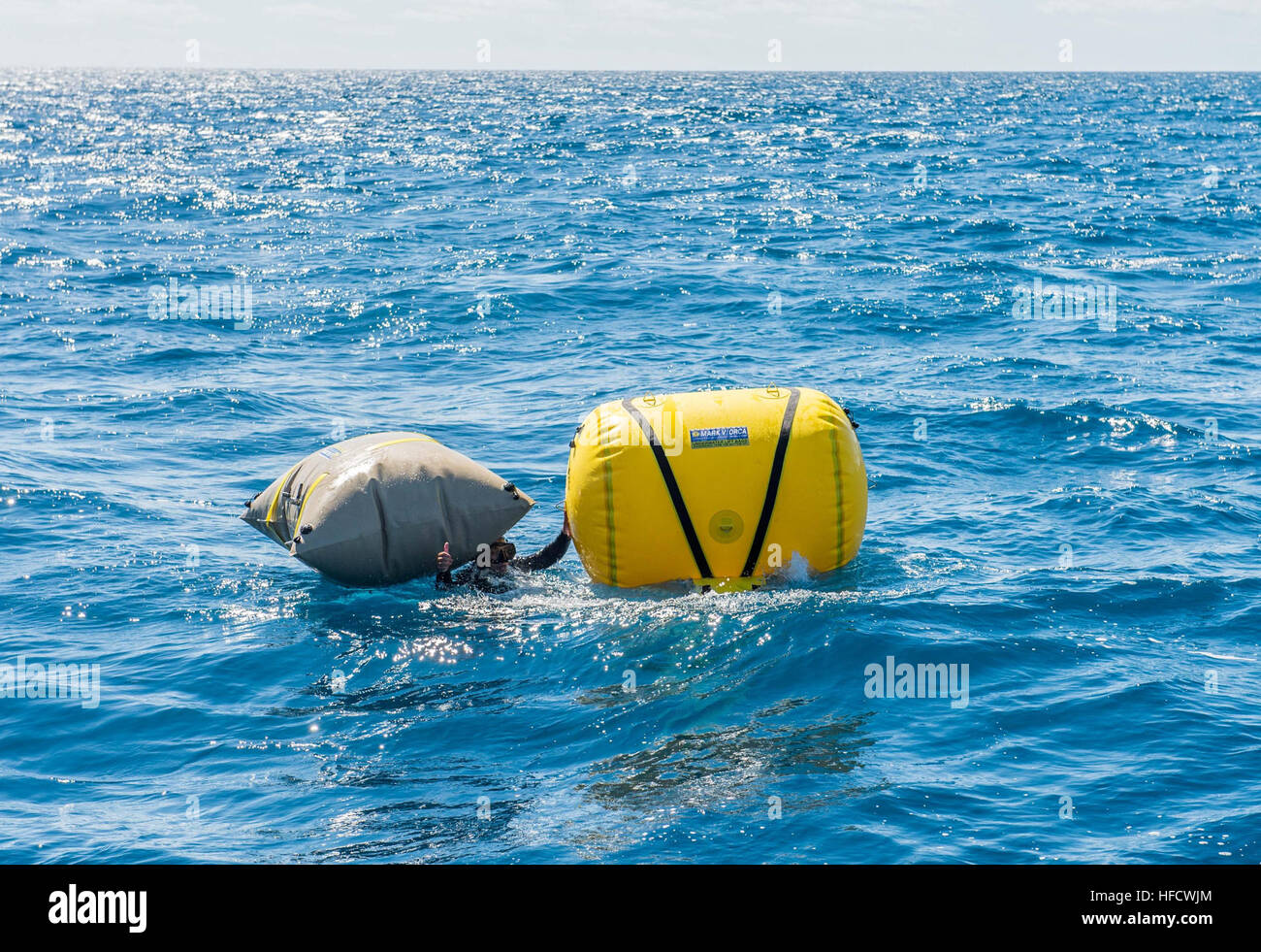 A Sailor from EODMU 5 attaches a secondary flotation balloon to ...