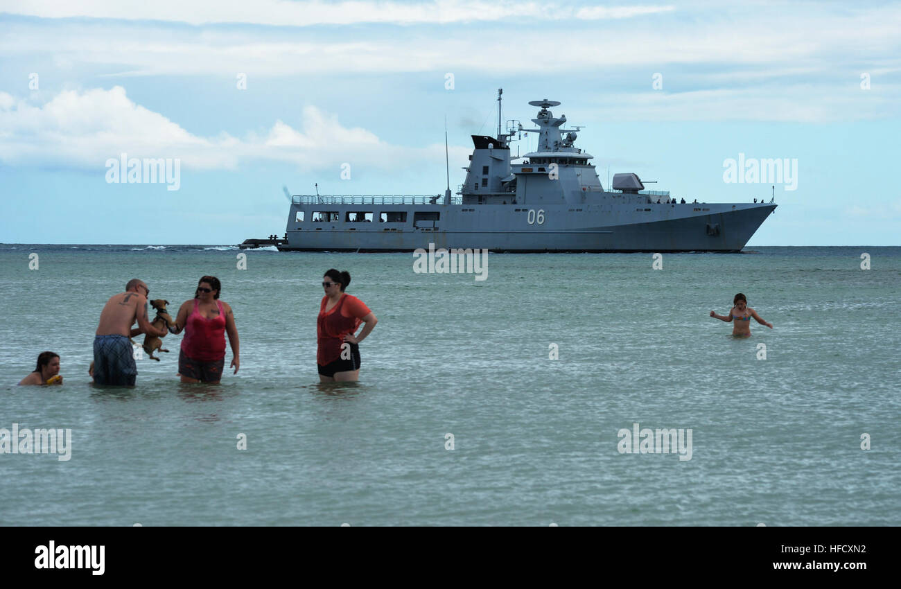 A family swims as the Royal Brunei Navy offshore patrol vessel KDB Darussalam (OPV 06) arrives at Joint Base Pearl Harbor-Hickam, Hawaii, June 24, 2014, before participating in Rim of the Pacific (RIMPAC) 2014. RIMPAC is a U.S. Pacific Command-hosted biennial multinational maritime exercise designed to foster and sustain international cooperation on the security of the world's oceans. (U.S. Navy photo by Mass Communication Specialist 2nd Class Laurie Dexter/Released) RIMPAC 2014 140624-N-GI544-132 Stock Photo