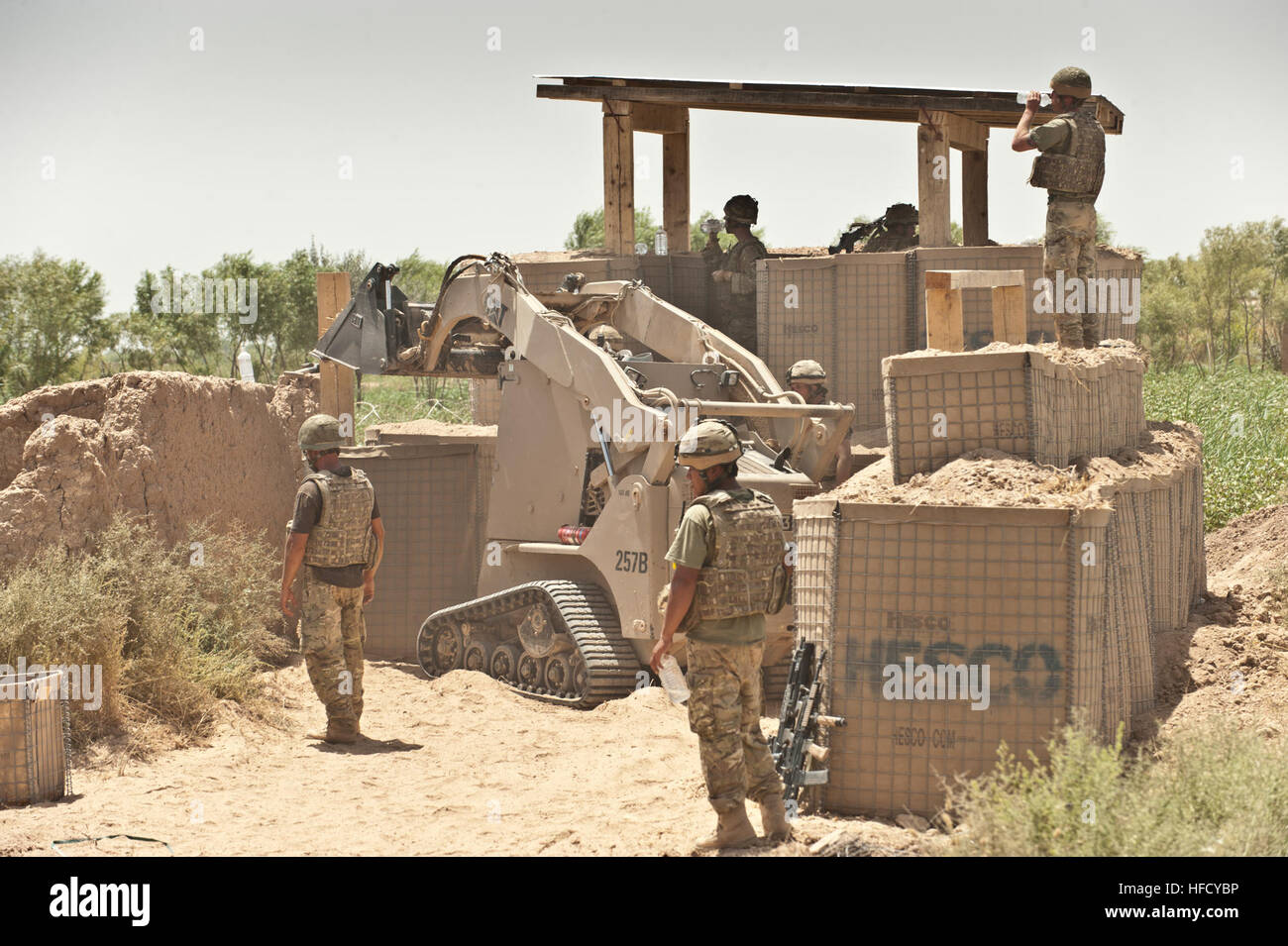 An engineer assigned to 59 Commando Squadron, Royal Engineers, drives a  tractor to move landscape and fill barriers in Lashkar Gah District,  Helmand province, July 25. The Engineers built the station for
