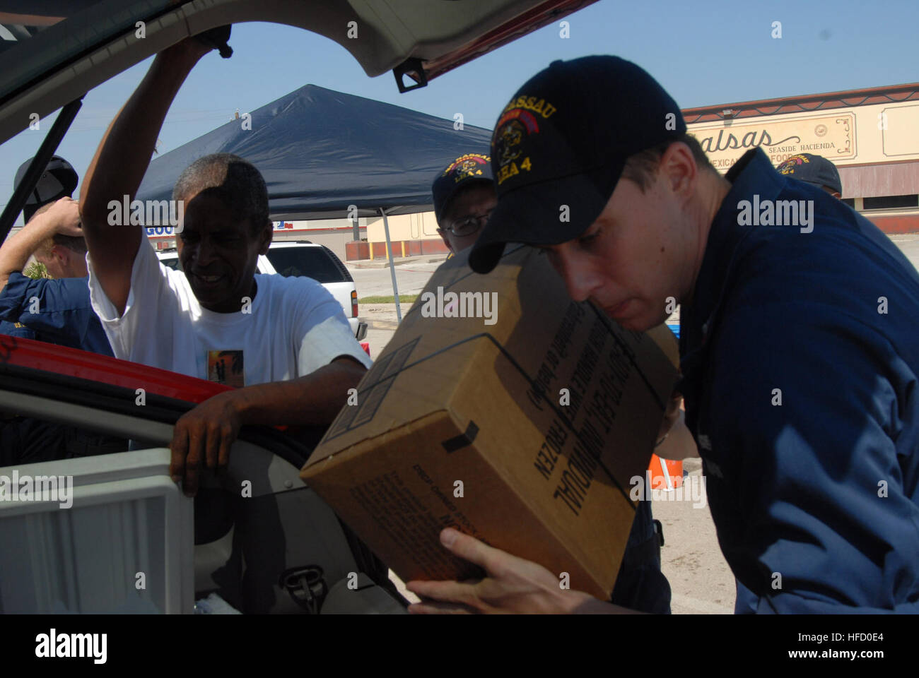 Petty Officer Class Colin Haller, a fire controlman stationed aboard USS Nassau, helps distribute essential supplies like food and water at Point of Distribution stations set up by the military in Galveston, Texas. Nassau is anchored off the coast of Galveston, Texas, to render disaster response and aid to civil authorities as directed in the wake of Hurricane Ike. Sailors distribute food, water at Point of distribution stations in Galveston 116754 Stock Photo