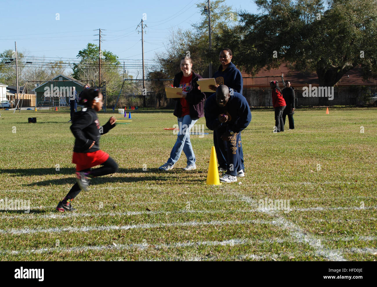 PASCAGOULA, Miss. (March 27, 2013) Hospital Corpsman 1st Class Henry Becoat times a child running a 30-meter sprint while Operations Specialist 2nd Class Lareine Boswell logs the results during field day athletic events at Central Elementary School. Sailors from Pre-Commissioning Unit (PCU) America (LHA 6) ran a variety of stations throughout the day including dizzy bat relay, egg and spoon relay, sack race, 30 yard dash and 50 yard dash. (U.S. Navy photo by Chief Mass Communication Specialist Laura James/Released) 130327-N-DV440-087 Join the conversation http://www.facebook.com/USNavy http:// Stock Photo