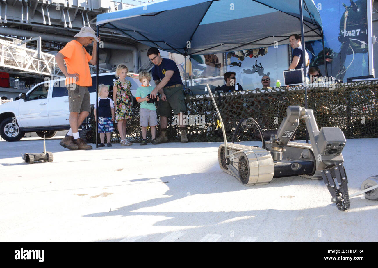 151111-N-NH654-004 SAN DIEGO (Nov. 11, 2015) Explosive Ordnance Disposal 2rd Class Louis Velarde explains to a visitor how to operate a robot during the Salute to Service Festival.  Explosive Ordnance Disposal Mobile Unit 11 is participating in the Salute to Service Festival, which is held annual on the USS Midway on Veterans Day. (U.S. Navy photo by Lieutenant Patricia Kreuzberger/Released) Salute to Service 151111-N-NH654-004 Stock Photo