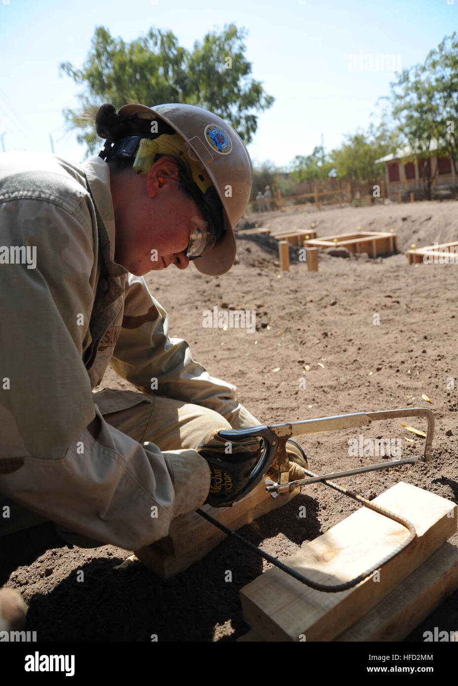Seaman 3rd Class Danielle Lang, assigned to Naval Mobile Construction Battalion NMCB 74 Detail Horn of Africa (Det. HOA), cuts steel rebar with a saw at a schoolhouse construction project in Dire Dawa, Ethiopia. NMCB 74 Det. HOA is deployed to Combined Joint Task Force-Horn of Africa to assist in building host nation partnerships and promoting regional stability by constructing schools, medical clinics, water wells and more throughout the region. Seabees Build Futures in Ethiopia 360209 Stock Photo