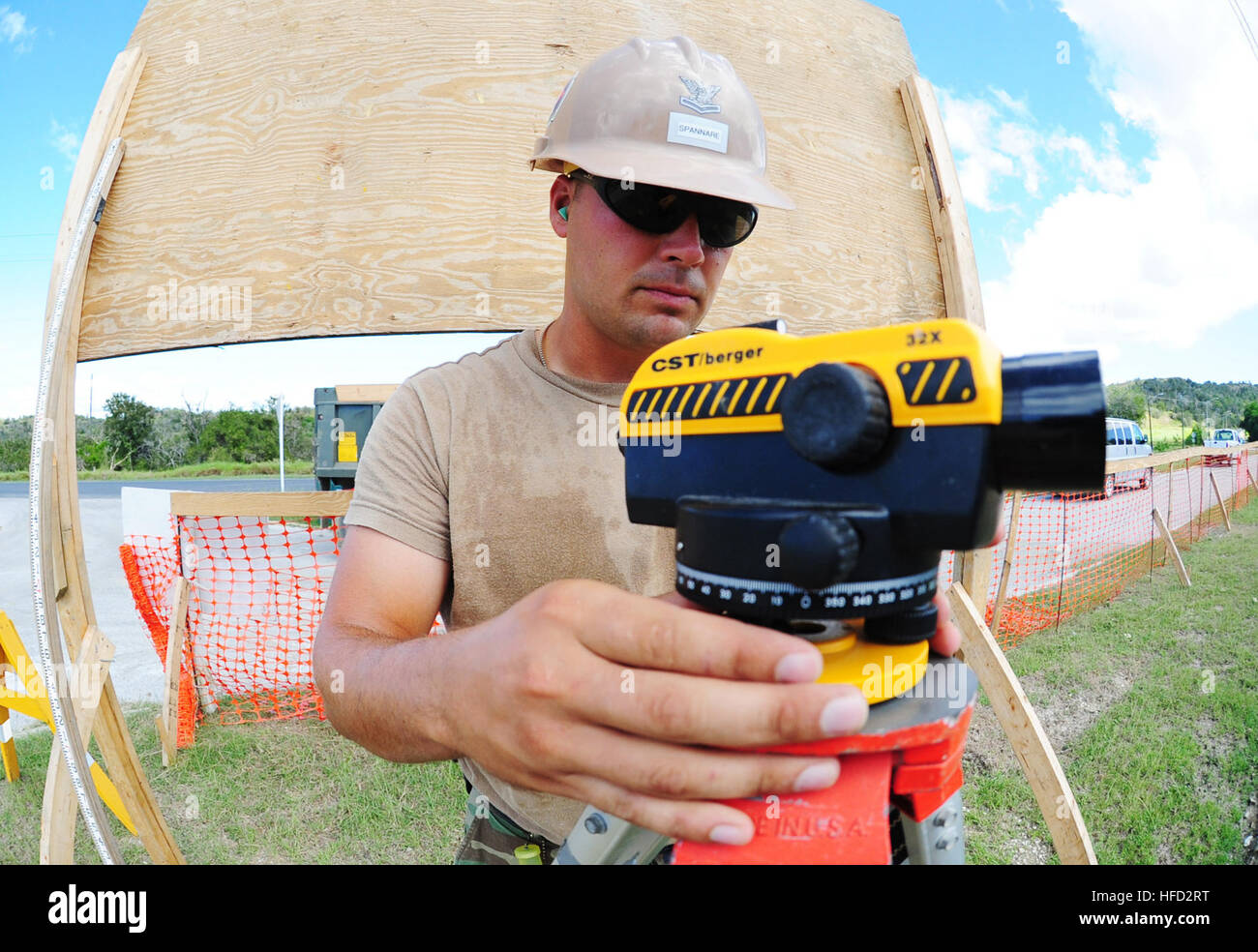 NAVAL STATION GUANTANAMO BAY, Cuba (Nov. 22, 2011) – Engineering Aide 2nd Class Matthew Spannare of Naval Mobile Construction Battalion 23, sets up an optical auto level to determine the elevation of a foundation they built for a new latrine at the Naval Station Guantanamo Bay golf center.  NMCB 23 is deployed in support of Joint Task Force Guantanamo and U.S. Naval Station Guantanamo Bay construction projects. (JTF Guantanamo photo by U.S. Navy Mass Communications Specialist 2nd Class Kilho Park) UNCLASSIFIED – Cleared for public release. For additional information contact JTF Guantanamo PAO  Stock Photo