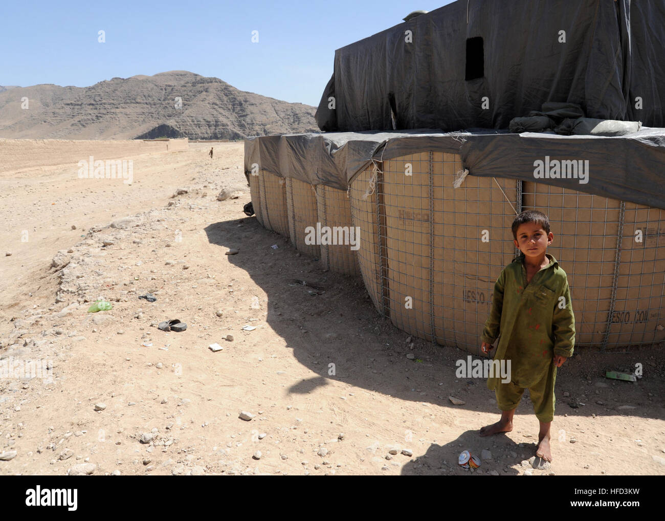 An Afghan boy stands next to a checkpoint in the village of Oshay, Shahid-E Hasas district, July 30. Checkpoints are designed to raise village security and are manned by Afghan National Security Forces (ANSF). Security checkpoint in Afghanistan 120730-N-OH262-643 Stock Photo