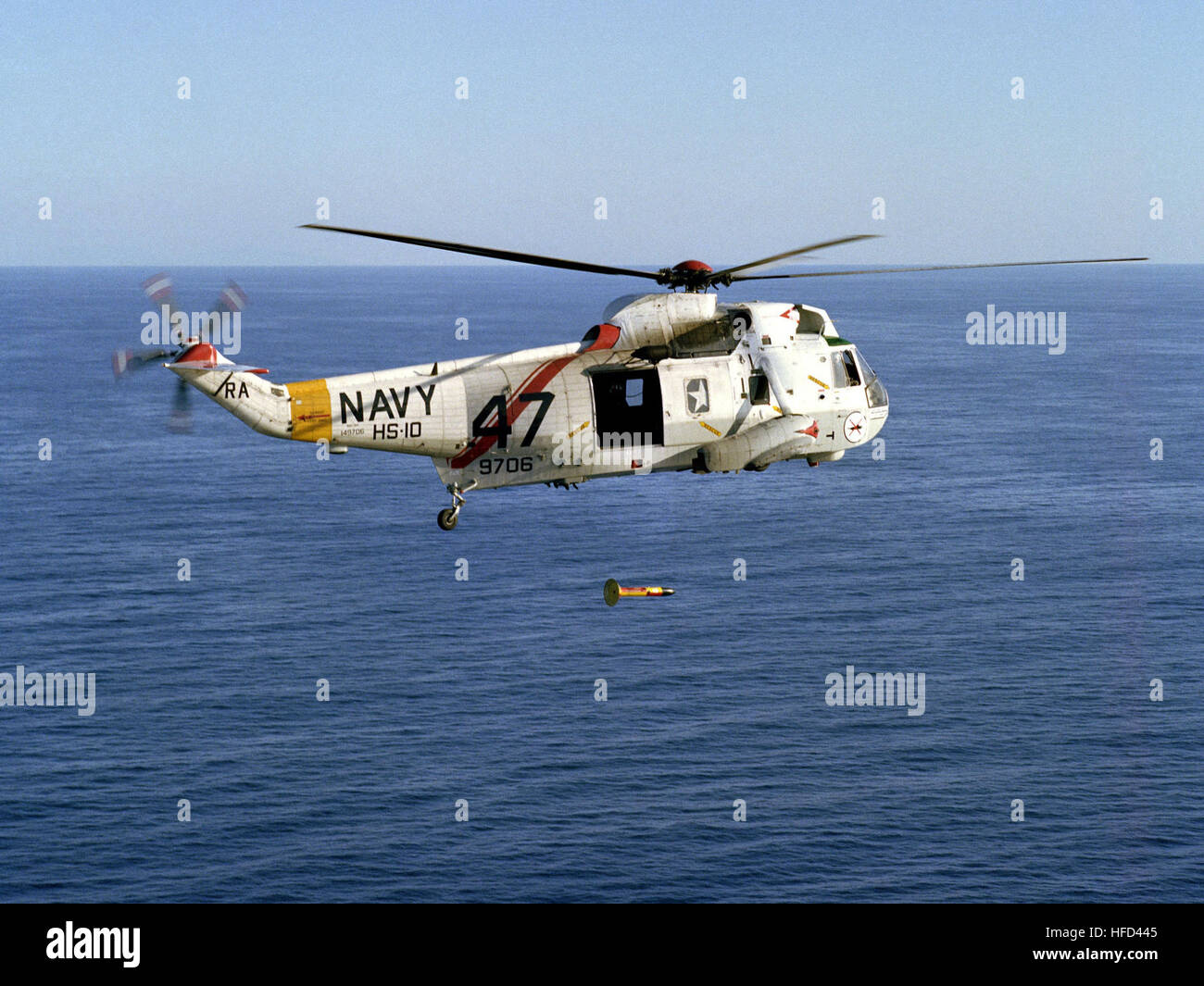 An air-to-air right side view of an SH-3 Sea King helicopter from Helicopter Anti-submarine Squadron 10 (HS-10), as it drops an AN/ASQ-81V Airborne Magnometer into the water during an anti-submarine warfare exercise. SH-3H of HS-10 in flight with lowered MAD sensor 1984 Stock Photo