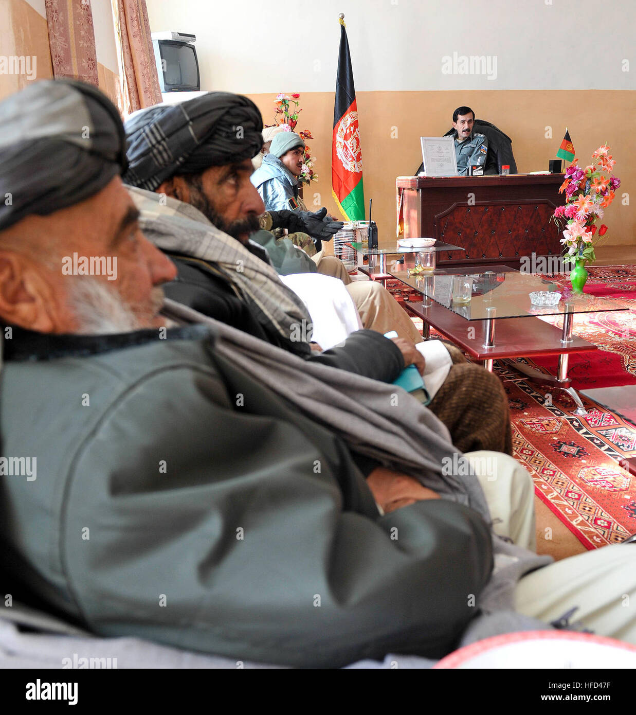 Shah Joy district leadership listen to the Shah Joy District Chief of