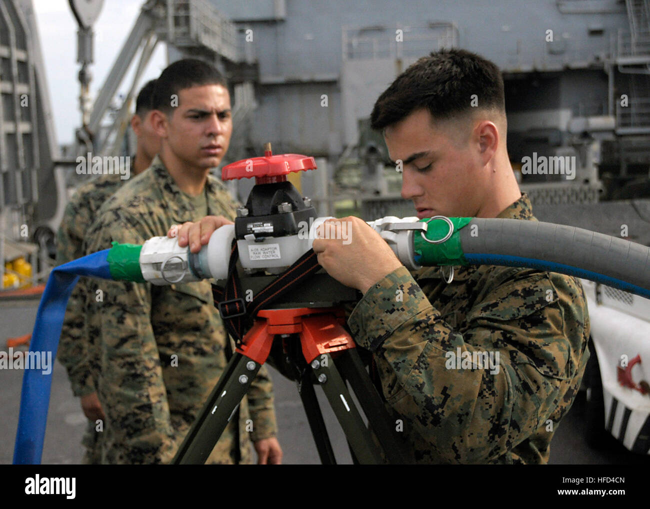 080523-N-5067K-289 ANDAMAN SEA (May 23, 2008) (May 17, 2008) U.S. Marine Lance Cpl. Alex Camargo, left, and Lance Cpl. Michael Dealba connect an intake suction hose to a Tactical Water Purifier System aboard the amphibious ship USS Harpers Ferry (LSD 49). The mobile water system can produce up to 1200 gallons of potable water under ideal conditions. Harpers Ferry is part of Joint Task Force Caring Response and is standing by in international waters off the coast of Burma preparing for a humanitarian assistance operation to help victims of Cyclone Nargis. U.S. Navy photo by Mass Communication S Stock Photo