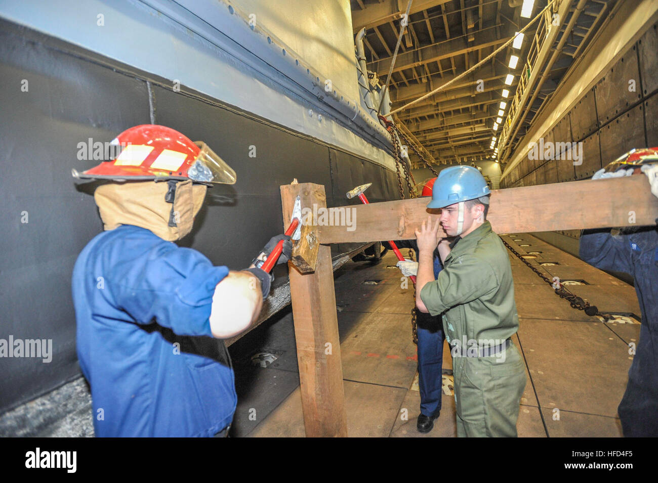 Sailors from deck department of the amphibious assault ship USS Boxer (LHD 4) remove shoring in the well deck. Boxer is the flagship for the Boxer Amphibious Ready Group and, with the embarked 13th Marine Expeditionary Unit, is deployed in support of maritime security operations and theater security cooperation efforts in the U.S. 5th Fleet area of responsibility. (U.S. Navy Photo by Mass Communication Specialist 3rd Class J. Michael Schwartz/Released) Shoring job 131222-N-QP351-066 Stock Photo