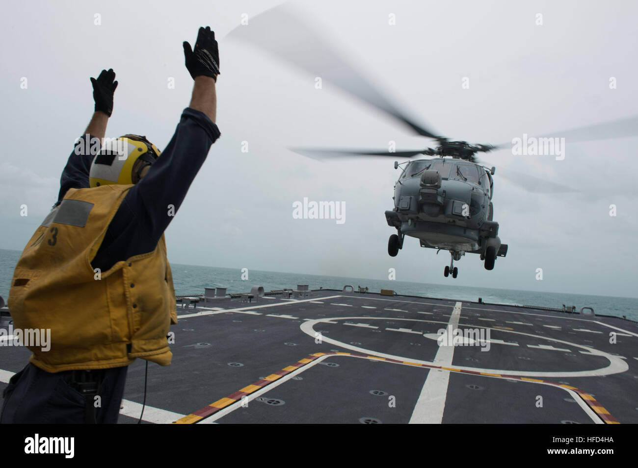 Boatswain’s Mate 2nd Class Adam Garnett signals an MH-60R Seahawk helicopter from Helicopter Maritime Strike Squadron (HSM) 35 on the flight deck of the littoral combat ship USS Fort Worth (LCS 3). Fort Worth is currently on station conducting helicopter search and recovery operations as part of the Indonesian-led efforts to locate missing AirAsia Flight QZ8501. (U.S. Navy photo by Mass Communication Specialist 2nd Class Antonio P. Turretto Ramos) Signalling an MH-60R Seahawk helicopter from Helicopter Maritime Strike Squadron (HSM) 35 on the flight deck of the littoral combat ship USS Fort Wo Stock Photo