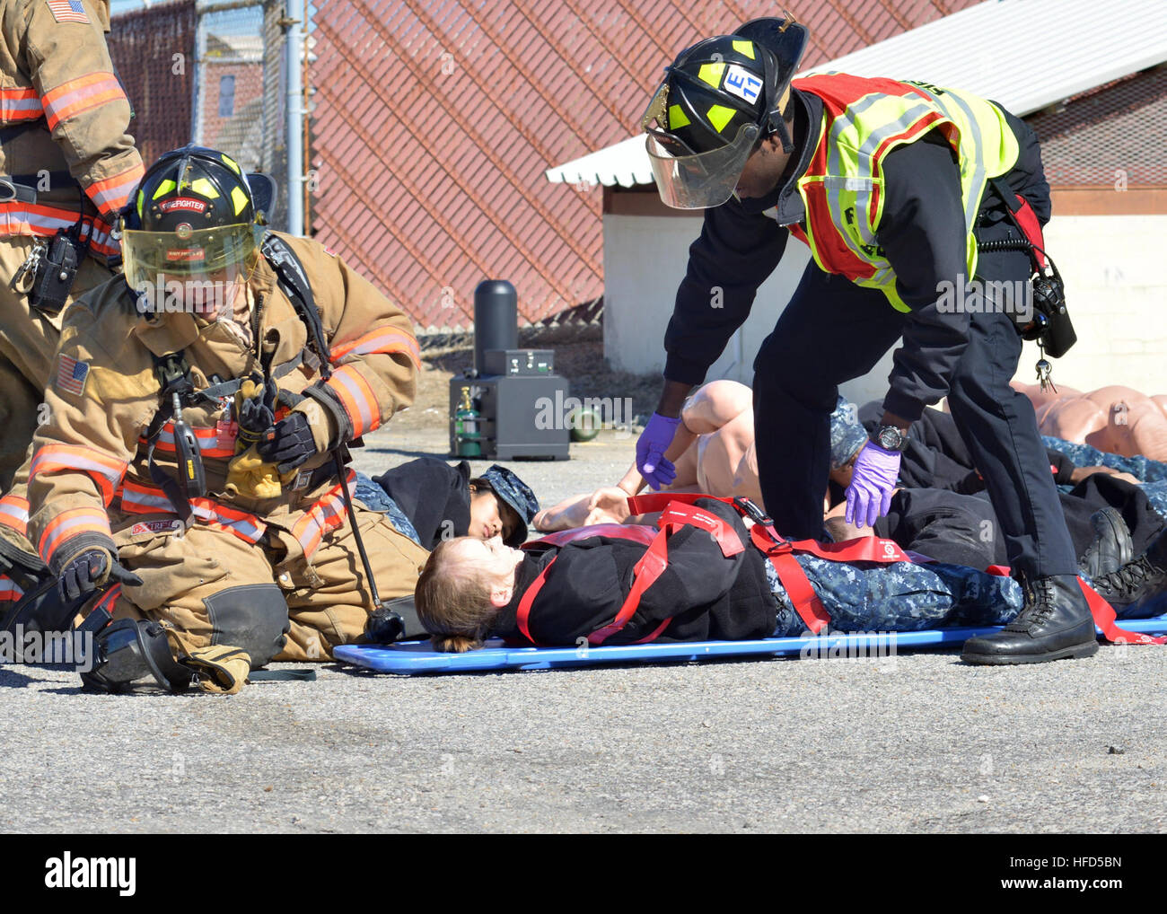 U.S. Navy firefighters with the Region Mid-Atlantic Fire and Rescue assist in a simulated casualty during a vehicle-borne improvised explosive device response exercise as part of Solid Curtain-Citadel Shield (SC-CS) 2014 at Naval Station Norfolk, Va., Feb. 27, 2014. The SC-CS is an annual exercise designed to enhance the training and readiness of U.S. Navy security forces to respond to threats to installations and units. (U.S. Navy photo by Mass Communication Specialist 2nd Class Molly Greendeer/Released) Solid Curtain-Citadel Shield 2014 140227-N-YC505-033 Stock Photo