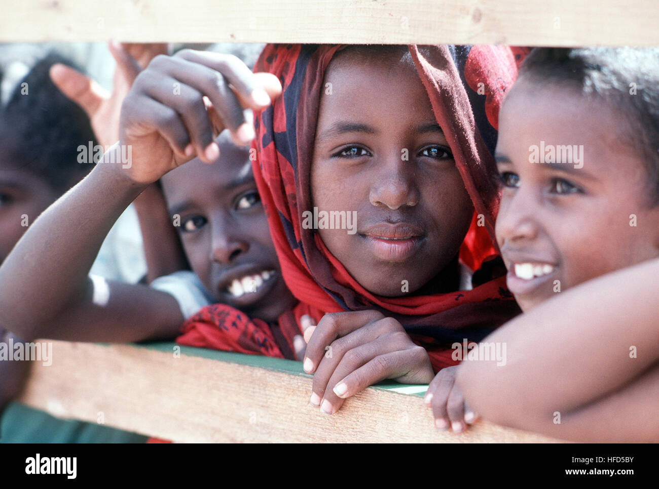 Somali children watch members of Naval Mobile Construction Battalion 1 (NMCB-1) as they work to improve a local school during the multinational relief effort OPERATION RESTORE HOPE. Somali children Stock Photo
