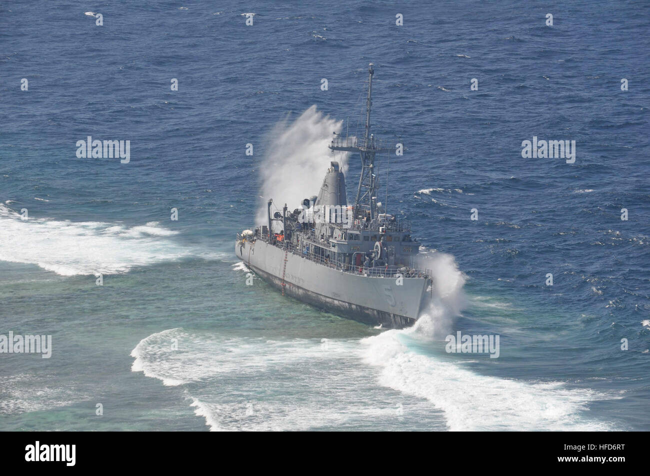 SULU SEA (Jan. 29, 2013) Heavy waves crash against the grounded mine countermeasure ship USS Guardian (MCM 5), which ran aground on the Tubbataha Reef in the Sulu Sea on Jan. 17. The grounding and subsequent heavy waves constantly hitting Guardian have caused severe damage, leading the Navy to determine the 23-year old ship is beyond economical repair and is a complete loss. With the deteriorating integrity of the ship, the weight involved, and where it has grounded on the reef, dismantling the ship in sections is the only supportable salvage option. The U.S. Navy continues to work in close co Stock Photo