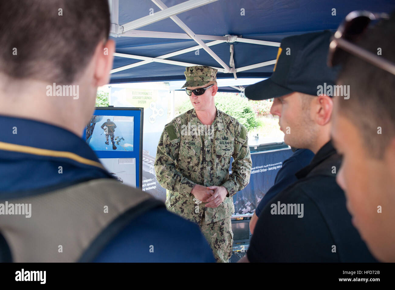 Explosive Ordnance Disposal Technician 2nd Class Clifford C. Jordan, of Explosive Ordnance Disposal Mobile Unit Six (EODMU-6), describes the capabilities of the Qinetiq Talon Explosive Ordnance Disposal robot to cadets from the Colts Neck High School Naval Junior Reserve Officers' Training Corps as part of Star-Spangled Spectacular. Star-Spangled Spectacular will run from Sept. 10-16, 2014, and celebrates the bicentennial of the Battle of Baltimore, which provided the backdrop for Francis Scott Key's famous poem, 'Defense of Fort McHenry,' which later became America's national anthem. (U.S. Na Stock Photo