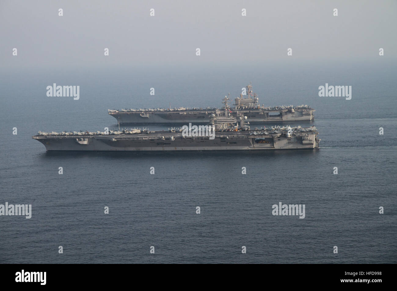 The aircraft carrier USS Carl Vinson (CVN 70), foreground, relieves the aircraft carrier USS George H.W. Bush (CVN 77) in the Persian Gulf Oct. 18, 2014, during Inherent Resolve. The George H.W. Bush was to leave the U.S. 5th Fleet area of responsibility for its home port in Norfolk, Va. President Barack Obama authorized humanitarian aid deliveries to Iraq as well as targeted airstrikes to protect U.S. personnel from extremists known as the Islamic State in Iraq and the Levant. U.S. Central Command directed the operations. (U.S. Navy photo by Lt. Juan D. Guerra/Released) The aircraft carrier U Stock Photo