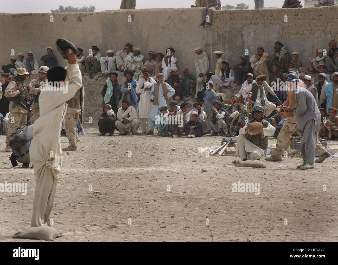 A large crowd of local Afghani villagers gathered at Camp Harriman, located in the Orgun Province of Afghanistan, to watch the first ever Afghani Little League Baseball Teams, consisting of two teams the Eagles ('Sahein' in Arabic) and The Afghan Club, play a game of baseball, during Operation ENDURING FREEDOM. Afghan teens playing American baseball game Stock Photo