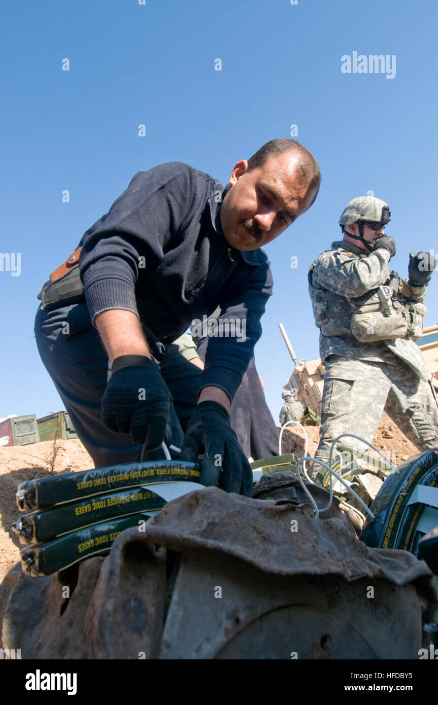 U.S. Air Force Senior Airman Nyx Zaid Nieves Lopez, a videographer with Joint Combat Camera at Forward Operating Base Warrior, rolls tape while a U.S. Air Force Explosive Ordnance Disposal team uses a radio detonation unit to explode charges set on unspent munitions that were left over from the Iran/Iraq war, along with other weapons seized from insurgents by the Iraq police in Kirkuk, Iraq, Dec. 13. U.S. Air Force Explosive Ordnance Disposal Detonation 139837 Stock Photo