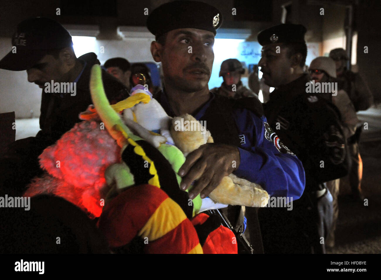 Iraqi police remove stuffed animals and candy from their vehicles during a walking patrol along the 60th Street Market area meeting Iraqi civilians, handing out toys to the children and speaking with local business owners, Nov. 15, in the Al Doura community located in southern Baghdad, Iraq. U.S. Air Force Joint Patrol 130571 Stock Photo