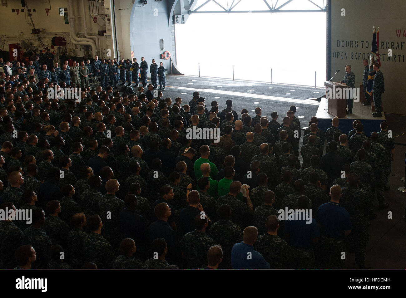 U.S. Navy Capt. Robert A. Hall Jr., at lectern, the commanding officer
