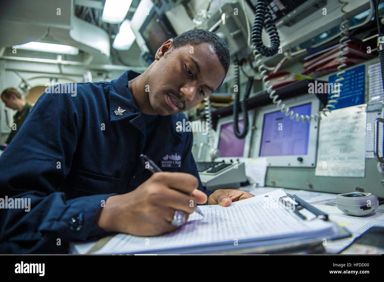 U.S. Navy Electrician's Mate 2nd Class Marquis Williams, assigned to the  guided missile destroyer USS Mustin (DDG 89), stands watch inside the  ship's engineering control center in the Pacific Ocean Sept. 22,