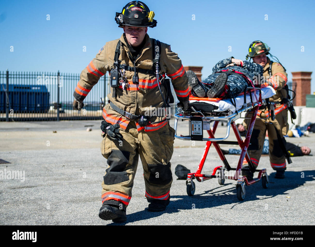 U.S. Navy firefighters treat a simulated casualty Feb. 27, 2014, during a vehicle-borne improvised explosive device response exercise as part of Solid Curtain-Citadel Shield (SC-CS) 2014 at Naval Station Norfolk, Va. SC-CS is an annual exercise designed to enhance the training and readiness of U.S. Navy security forces to respond to threats to installations and units. (U.S. Navy photo by Mass Communication Specialist 3rd Class Andrew Schneider/Released) U.S. Navy firefighters treat a simulated casualty Feb. 27, 2014, during a vehicle-borne improvised explosive device response exercise as part  Stock Photo