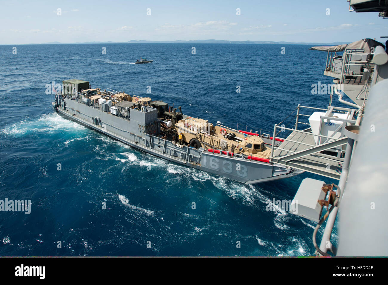 A landing craft utility departs the well deck of the forward-deployed ...