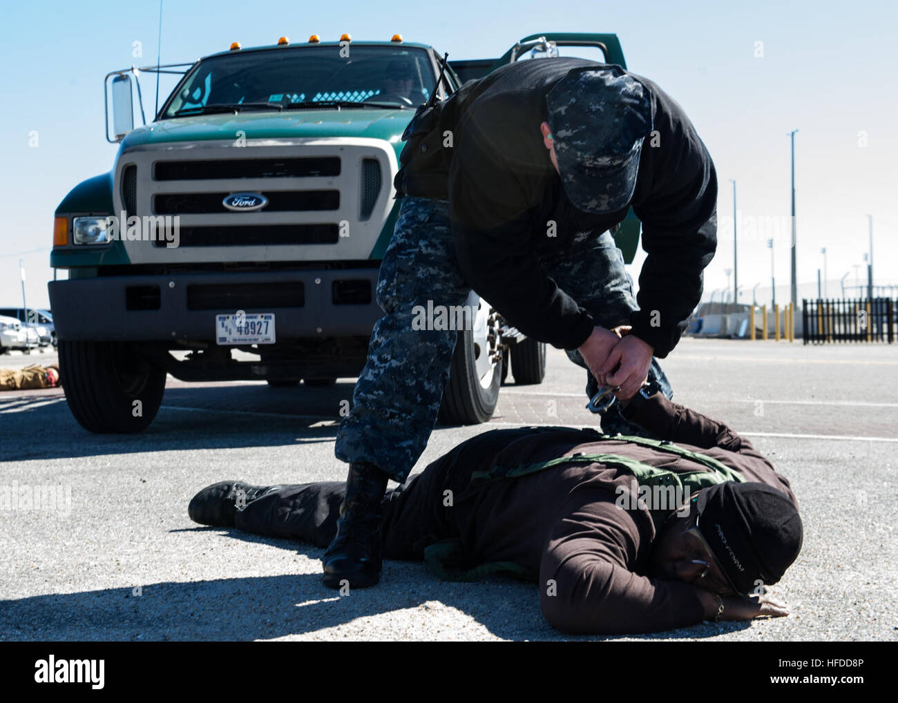 U.S. Navy Master-at-Arms 2nd Class Robert Heckerman, standing, subdues Charles Streat after disarming him Feb. 27, 2014, during a vehicle-borne improvised explosive device response exercise as part of Solid Curtain-Citadel Shield (SC-CS) 2014 at Naval Station Norfolk, Va. SC-CS is an annual exercise designed to enhance the training and readiness of U.S. Navy security forces to respond to threats to installations and units. (U.S. Navy photo by Mass Communication Specialist 3rd Class Andrew Schneider/Released) U.S. Navy Master-at-Arms 2nd Class Robert Heckerman, standing, subdues Charles Streat  Stock Photo