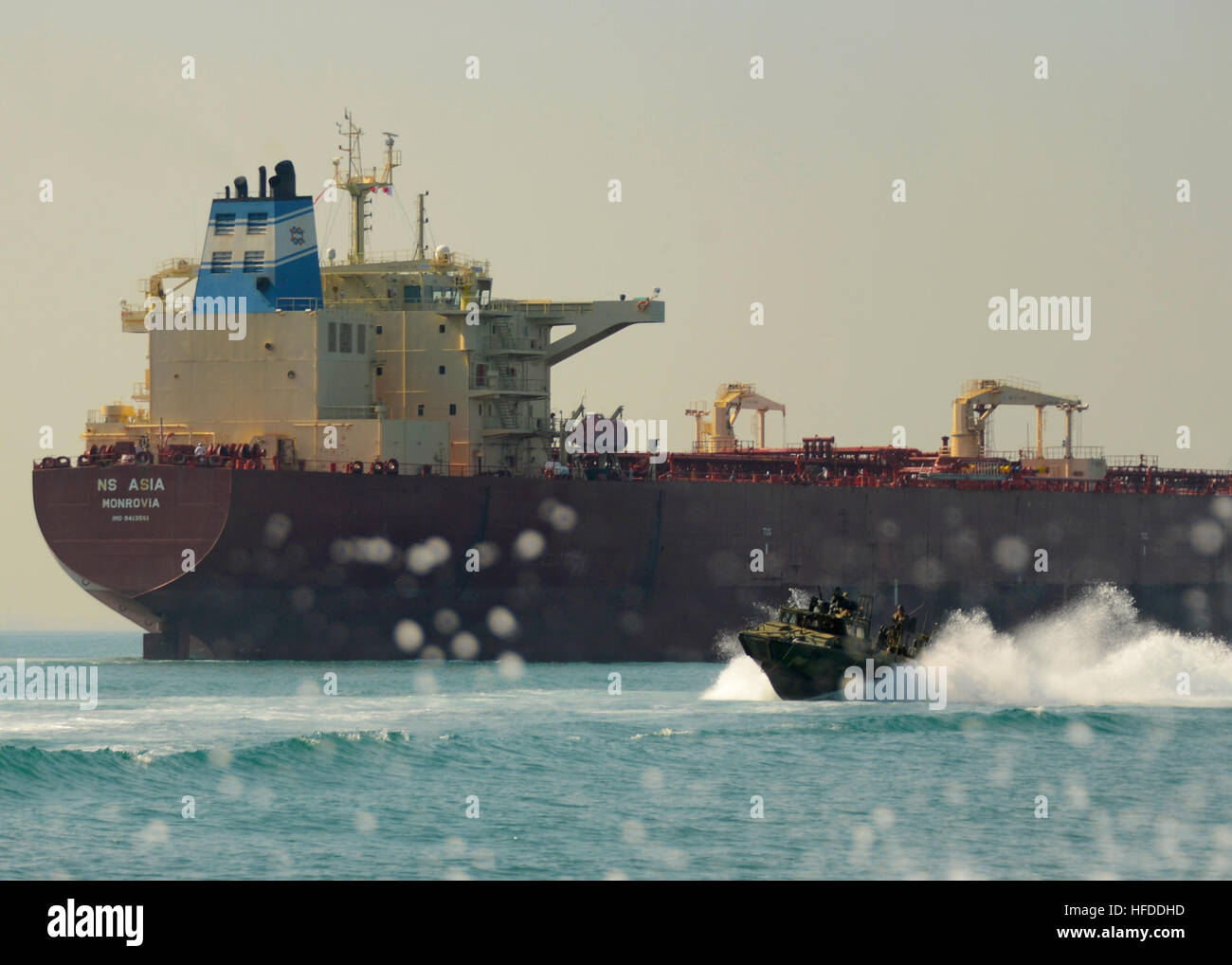 U.S. Sailors aboard a riverine command boat (RCB) assigned to Commander Task Group (CTG) 56.7 pass an oil tanker after completing a live-fire exercise in the Persian Gulf Dec. 12, 2013. RCB's provided a multimission platform for the U.S. 5th Fleet area of responsibility by focusing on maritime security operations, maritime infrastructure protection and theater security cooperation efforts, as well as conduct offensive combat operations. (U.S. Navy photo by Mass Communication Specialist 1st Class Corey Green/Released) U.S. Sailors aboard a riverine command boat (RCB) assigned to Commander Task  Stock Photo