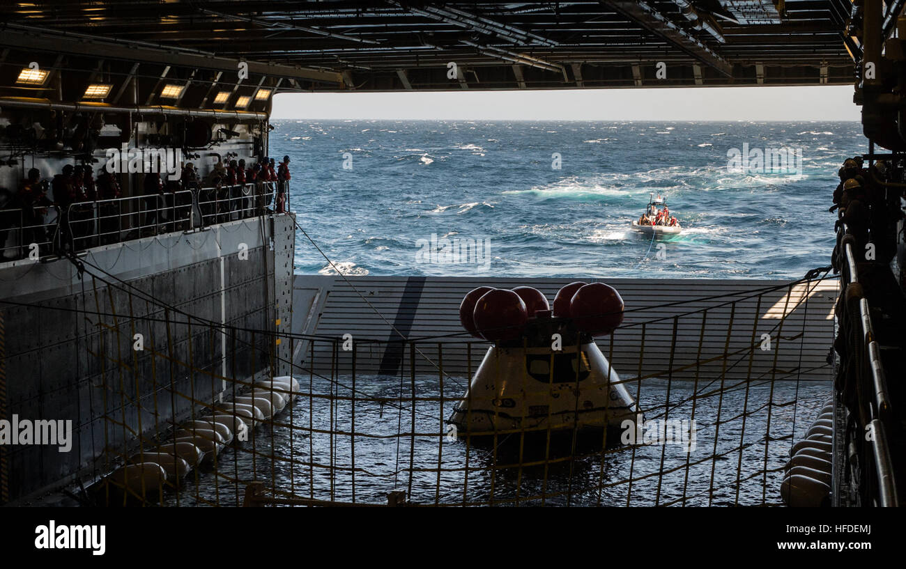 A NASA Orion crew module is pulled into position in the well deck of the amphibious transport dock ship USS Anchorage (LPD 23) during the Orion Program's fourth underway recovery test (URT-4). URT-4 is the fourth at-sea recovery testing of the Orion crew module using a well deck recovery method.  (U.S. Navy photo by Mass Communication Specialist 1st Class Charles White/Released) Underway recovery test 140917-N-GO855-078 Stock Photo