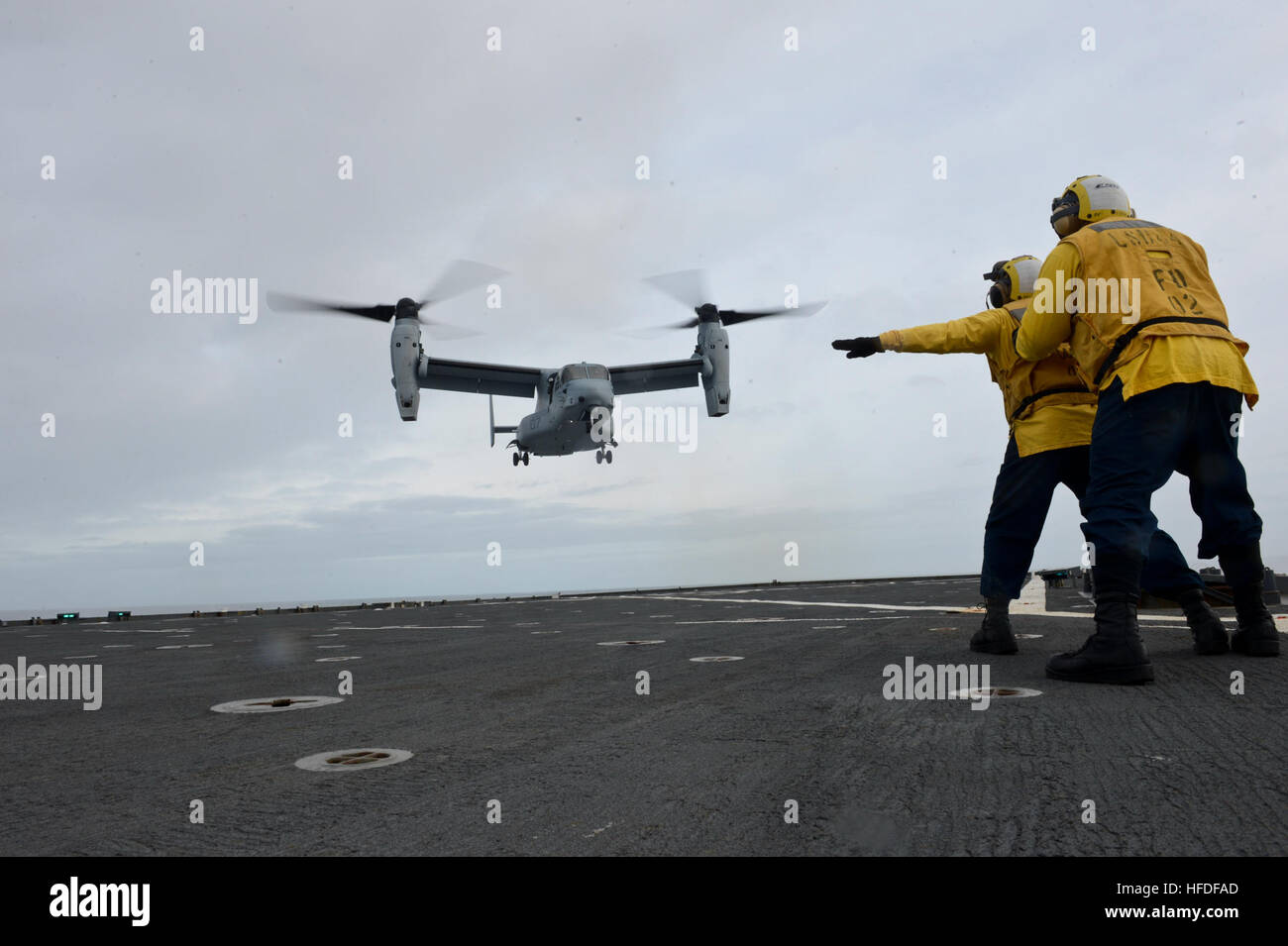 Boatswain's Mate 3rd Class directs a MV22 Osprey as it conducts