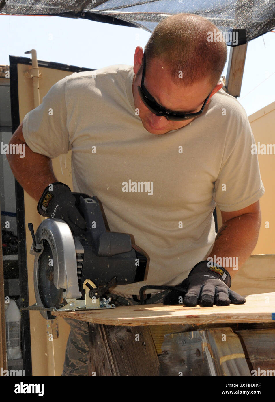GUANTANAMO BAY, Cuba – Air Force Staff Sgt. Gary Learmonth, of the 474th Expeditionary Civil Engineering Squadron, Base Emergency Engineer Force, Joint Task Force Guantanamo, uses a saw to cut plywood in Camp Justice, March 16, 2010. The 474th ECES maintains the Expeditionary Legal Complex, vital to the JTF mission. JTF Guantanamo conducts safe, humane, legal and transparent care and custody of detainees, including those convicted by military commission and those ordered released by a court. The JTF conducts intelligence collection, analysis and dissemination for the protection of detainees an Stock Photo