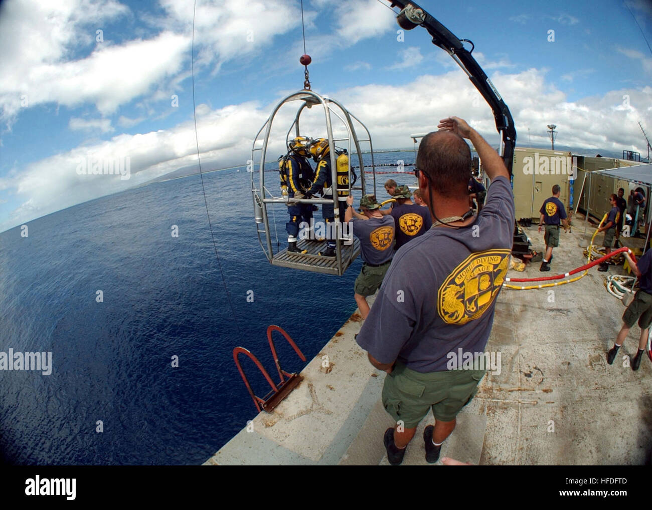 011031-N-3093M-032  --  Honolulu, Hawaii (Oct. 31, 2001)-- U.S. Navy divers are hoisted over the side to begin another dive to recover remains and personal effect from the Japanese fishing vessel Ehime Maru. U.S. Navy and Japanese divers are working together at the shallow water recovery site off the coast of Hawaii.  U.S. Navy Photo By Photographer's Mate Chief Petty Officer Andrew McKaskle.  (RELEASED) US Navy 011031-N-3093M-032 Navy diver salvage operations Stock Photo