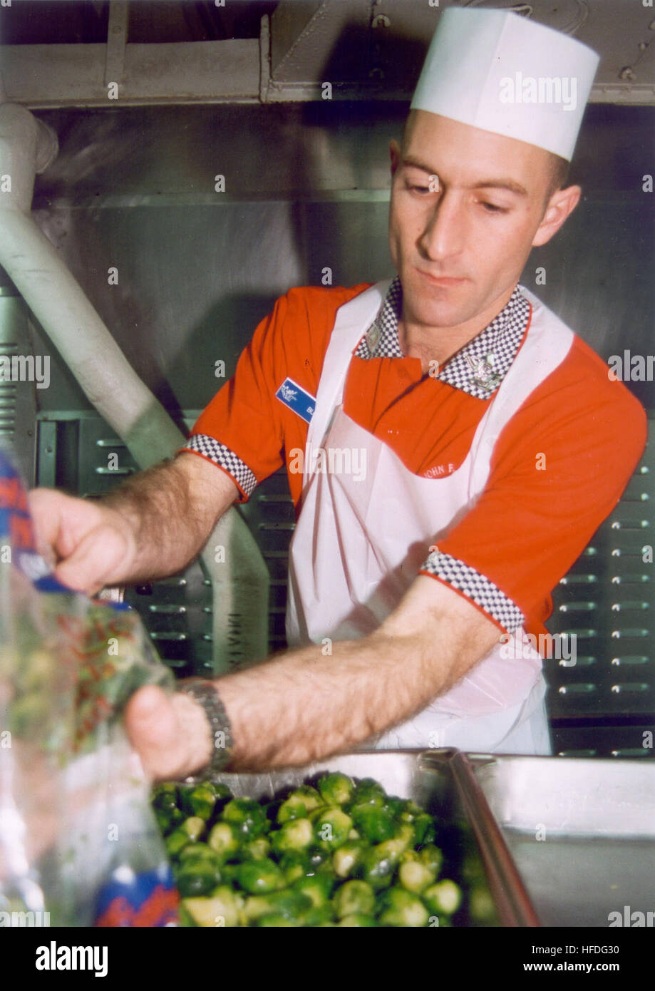 020213-N-7741S-004 At sea aboard USS John F. Kennedy (CV 67) Feb. 13, 2002 -- Mess Specialist 2nd Class Russell Burns from Calhoun City, Miss., prepares vegetables for midnight rations ÒMid-RatsÓ for crewmembers assigned to late night duties aboard ship.  John F. Kennedy and her embarked Carrier Air Wing (CVW) recently departed on a scheduled deployment, and will relieve USS Theodore Roosevelt (CVN 71) to conduct missions in support of Operation Enduring Freedom.  U.S. Navy photo by PhotographerÕs Mate Airman David Smith (RELEASED) US Navy 020213-N-7741S-004 Midnight food preparation aboard JF Stock Photo