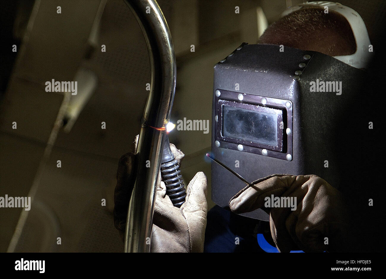 A Hull Technician welds the aft railing on the captain's gig aboard USS ...