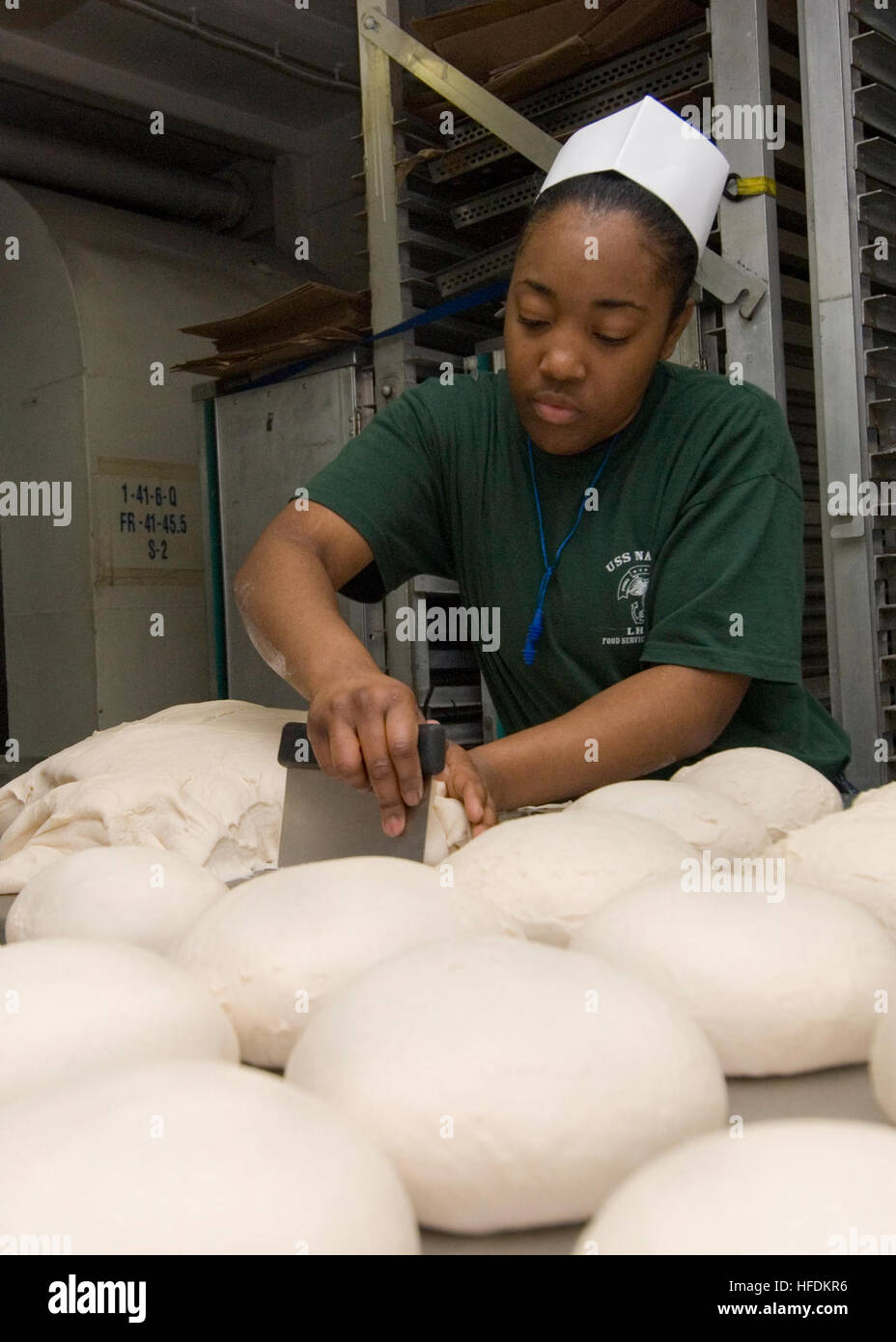 091108-N-6439C-017 ATLANTIC OCEAN (Nov. 8, 2009) Airman Lakendra Williams cuts bread dough in the bake shop aboard the amphibious assault ship USS Nassau (LHA 4) during a Composite Unit Training Exercise. The U.S. 2nd Fleet training exercise is conducted from Oct. 23 to Nov. 17 off the East Coast from Virginia to Florida. (U.S. Navy photo by Mass Communication Specialist 2nd class Amanda Clayton/Released) An Airman cuts bread dough aboard USS Nassau (LHA 4) Stock Photo