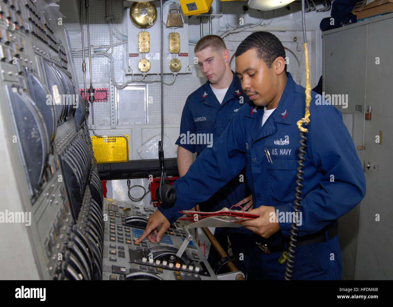 Petty Officer 1st Class Daniel Citizen, an engineman, from Lafayette, La., front, and Petty Officer 2nd Class David Larson, also an engineman, from Bigelow, Ark., prepare the main machinery room number 2 operating station for an operational test of the ship's number 2 bravo diesel engine aboard the amphibious dock landing ship USS Fort McHenry. Fort McHenry is participating in Operation Unified Response after a 7.0 magnitude earthquake caused severe damage in and around Port-a-Prince, Haiti Jan. 12. (Photo by: Petty Officer 1st Class Edward Kessler) An operational test 254872 Stock Photo