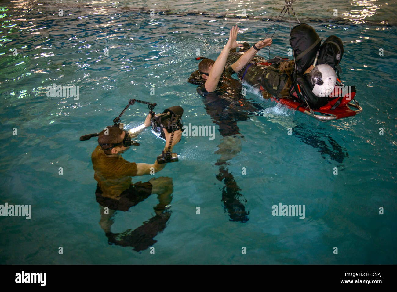 150206-N-YD328-081 Norfolk, Va. (Feb. 6, 2015)  Naval Aircrewman 2nd Class Jason A. Mackenzie straps Naval Aircrewman 3rd Class Miguel A. Guerrero, both assigned to Helicopter Sea Combat Squadron Nine, to a rescue litter as Mass Communication Specialist 2nd Class Michael Scichilone photographs during a personnel recovery exercise at Aviation Survival Training Center Norfolk (ASTC Norfolk). ASTC Norfolk is one of eight sites around the country that provides aviation survival and physiology training for all Naval Aviation and Department of Defense activities.  (U.S. Navy photo by Mass Communicat Stock Photo