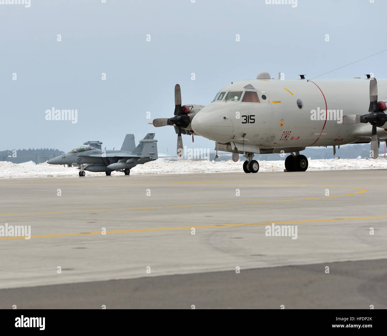 NAVAL AIR FACILITY MISAWA, Japan (Feb. 27, 2014) An EA-18G Growler aircraft, belonging to Electronic Attack Squadron (VAQ) 132, taxis past a P-3 Orion aircraft, belonging to Patrol Squadron 46, after arriving at Naval Air Facility Misawa, Feb. 27, 2014. The squadron is beginning a routine deployment on board the U.S. naval installation in support of U.S. 7th Fleet operations. VAQ-132 is homeported out of Naval Air Station Whidbey Island in Oak Harbor, Wash.  (U.S. Navy photo by Mass Communication Specialist 3rd Class Erin Devenberg/RELEASED) A U.S. Navy EA-18G Growler aircraft, left, attached  Stock Photo