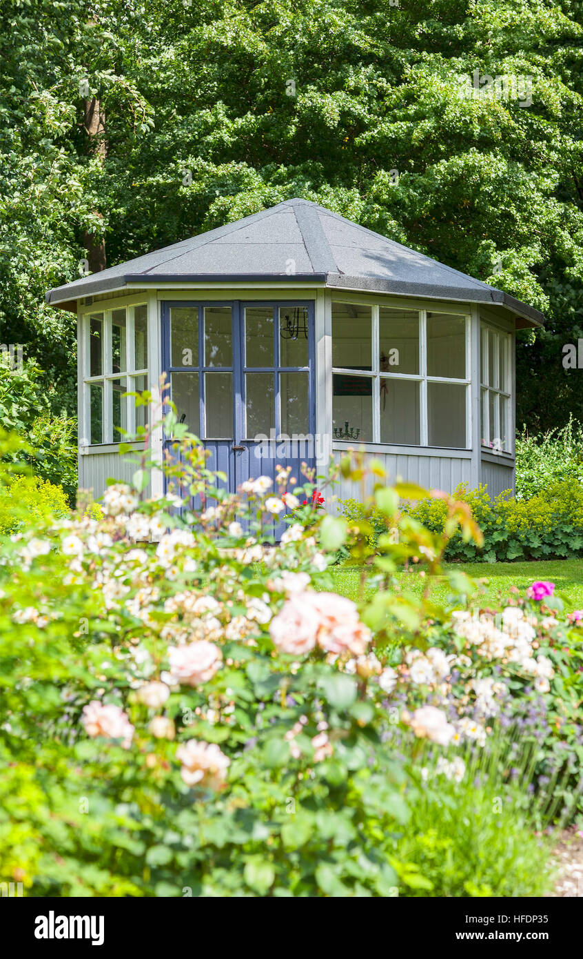 Image of lush garden with romantic gazebo. Stock Photo