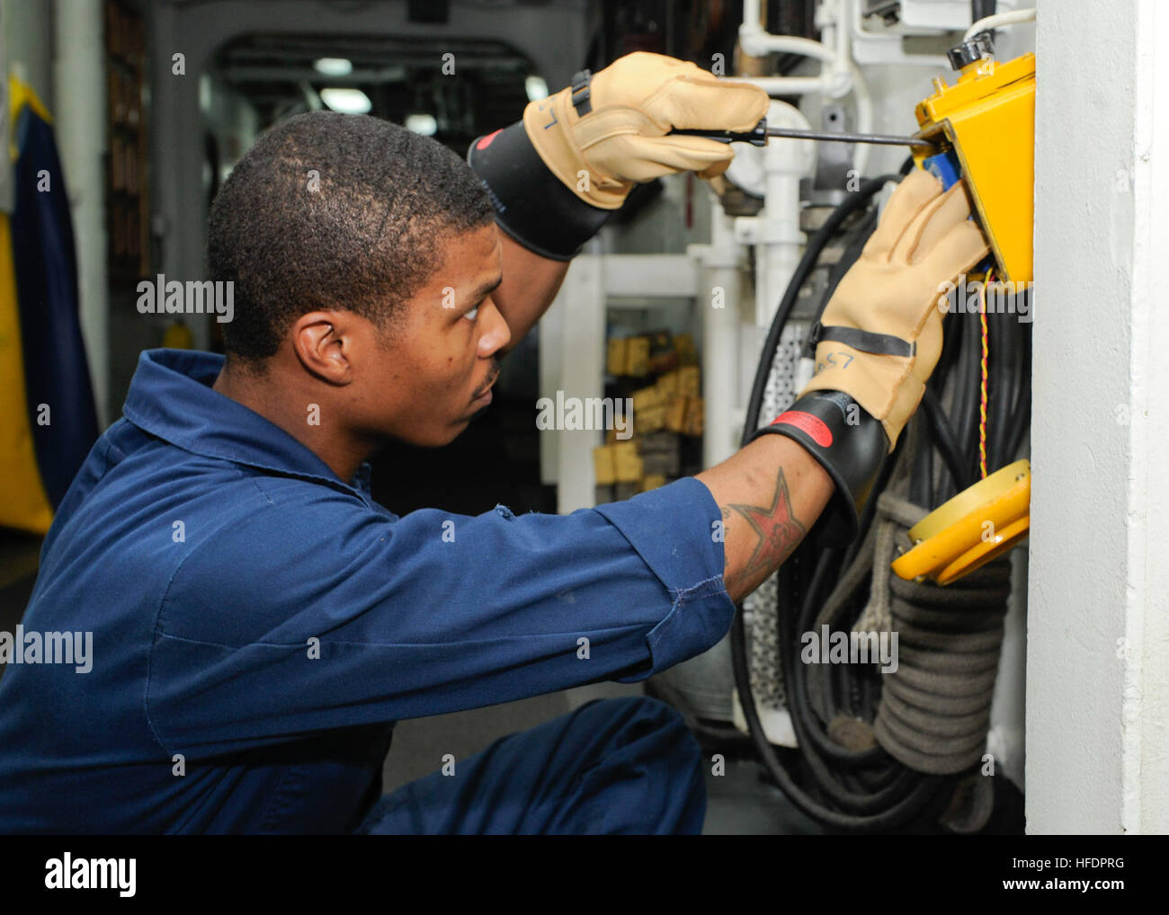 Aviation Support Equipment Technician 3rd Class Devon Short repairs a battle lantern aboard the amphibious assault ship USS Boxer (LHD 4). Boxer is the flagship for the Boxer Amphibious Ready Group and, with the embarked 13th Marine Expeditionary Unit, is deployed in support of maritime security operations and theater security cooperation efforts in the U.S. 5th Fleet area of responsibility. (U.S. Navy photo by Mass Communication Specialist 3rd Class Robert R. Sanchez/Released) Battle lantern repair 131203-N-OQ305-029 Stock Photo