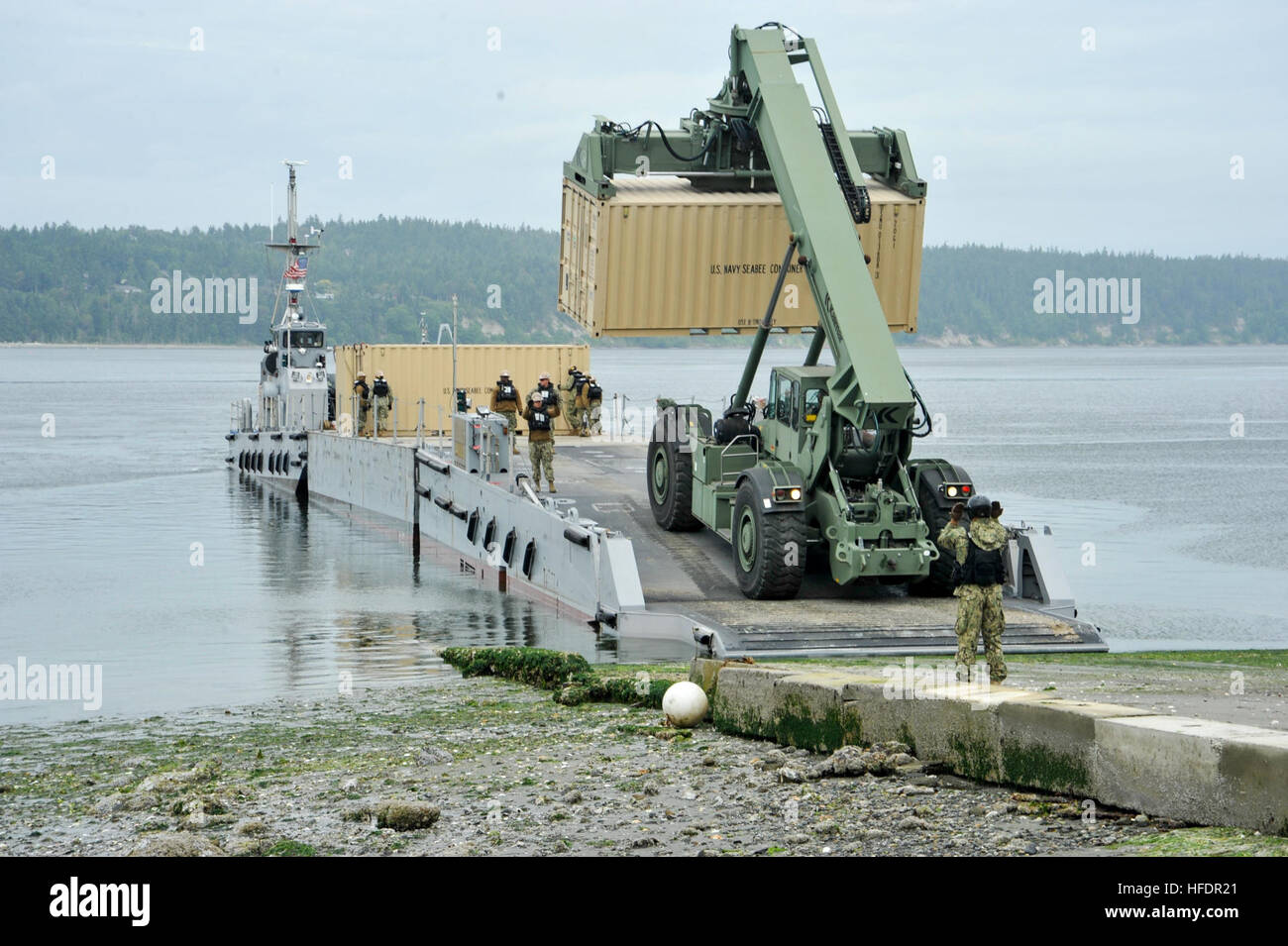 INDIAN ISLAND, Wash. (June 8, 2016) Beach Master Unit 1, from Coronado, California, removes a conex box from a floating causeway during the Joint Logistics Over-the-Shore (JLOTS) exercise. JLOTS is the process by which rolling stock and containers of military cargo are moved from ship to shore without the benefit of a port. The exercise is also part of the operation Cascadia Rising, an emergency preparation operation. (U.S. Navy photo by Mass Communication Specialist 3rd Class Charles D. Gaddis IV/Released)160608-N-EC099-123  Join the conversation: http://www.navy.mil/viewGallery.asp http://ww Stock Photo