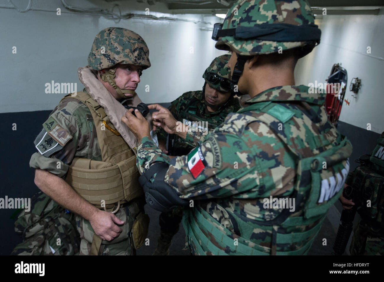 Members of the Mexican Naval Infantry Force help a French Legionaire don water survival gear prior to departing amphibious assault ship USS Kearsarge (LHD 3) via helicopter during the multi-national exercise Bold Alligator 2014 (BA14). Improving Navy-Marine Corps amphibious core competencies along with coalition, North Atlantic Treaty Organization (NATO), Allied and partner nations is a necessary investment in the current and future readiness of our forces. BA14 will take place Oct. 29 - Nov. 10, 2014, afloat and ashore along the eastern seaboard. #BA14 (U.S. Navy photo by Mass Communication S Stock Photo