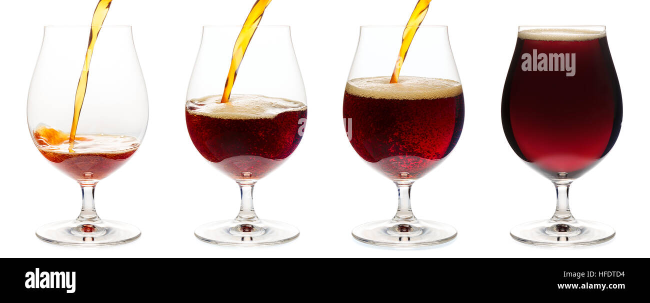 Dark ale or porter beer is pouring into snifter glass isolated on white background Stock Photo