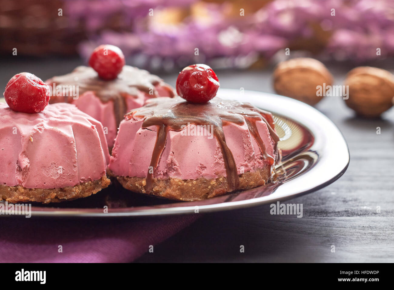 Raw vegan dessert made with sour cherry, dates and walnuts served on black plate Stock Photo