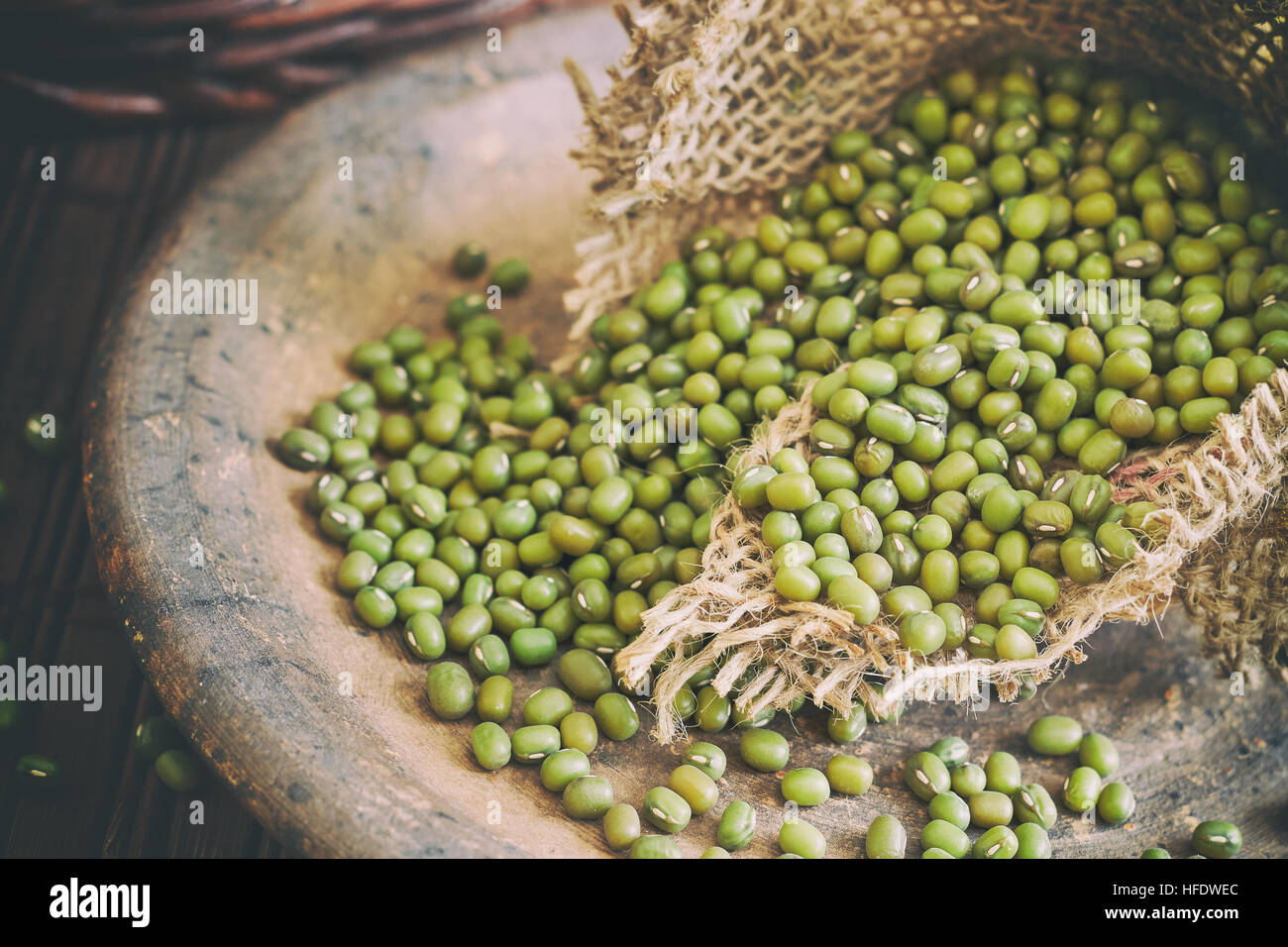 Raw mung beans (Vigna radiata) spilling from burlap bag Stock Photo