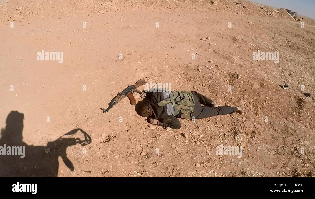 WARNING: GRAPHIC CONTENT: Still image taken from an ISIS propaganda video showing the shadow of an Islamic State militant standing over the body of a Syrian backed fighter during battles in Syria in an area described as Homs province December 11, 2016 near Palmyra, Syria. Stock Photo