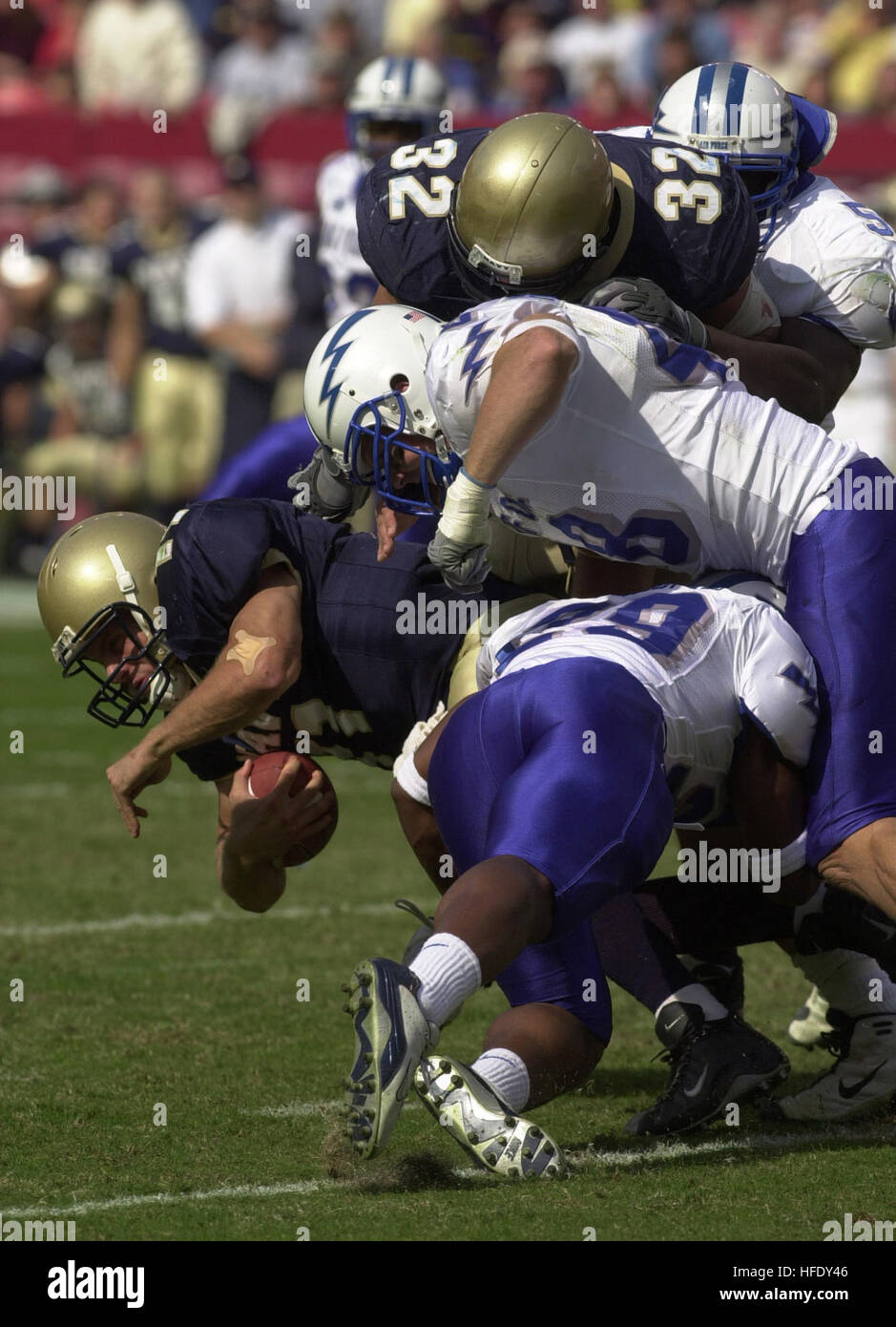 031004-N-6157F-013 Landover, Md. (Oct. 4, 2003) Navy senior quarterback Craig Candeto is tackled by Air Force free safety Larry Duncan and linebacker John Rudzinski. Navy upset Air Force 25-28 in the inter-service game at FedEx field in Landover, Md. The Midshipmen snapped a six-game losing streak to the Falcons with the victory. The victory put Navy in excellent position to win the Commander-In-Chief's Trophy, awarded to the team with the best record in games between the three major service academies. The trophy will be up for grabs when Navy plays Army Dec. 6. U.S. Navy photo by Journalist 1 Stock Photo