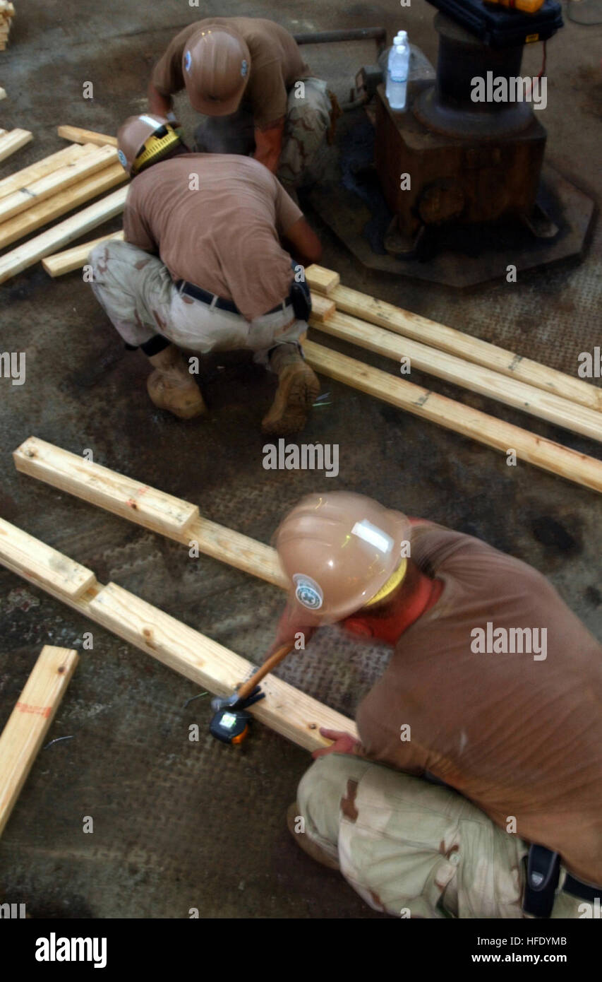 040517-N-9885M-064 Northern Arabian Gulf (May 17, 2004) - U.S. Navy Seabees hammer together pieces of wood that will be used to make bunk beds for security forces on board the Al Basrah Oil Terminal (ABOT). U.S. Navy Seabees from Naval Support Activity (NSA) Bahrain are making improvements for the living conditions of the Interim Marine Corps Security Force (IMCSF) company from Bahrain, and Iraqi Security Forces that provide vital protection to the terminals. Since July 2003, Al Basrah and Khawr Al Amaya oil terminals have pumped more than 385 million barrels of oil to more than 235 tankers, r Stock Photo